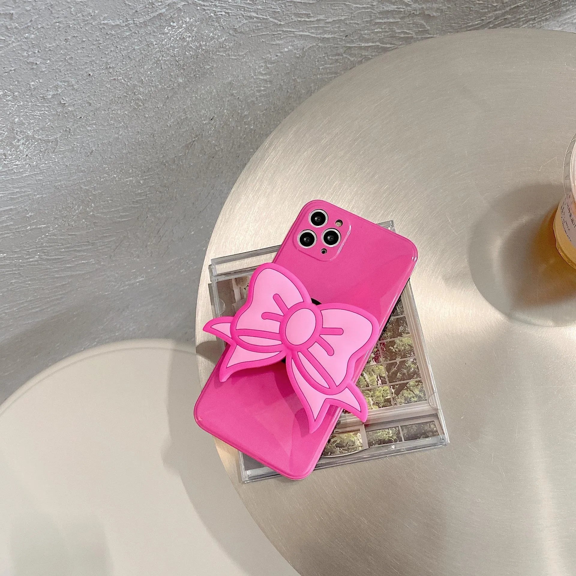 Rose Red iPhone case with pink bow design and a folded-out kickstand on the back.