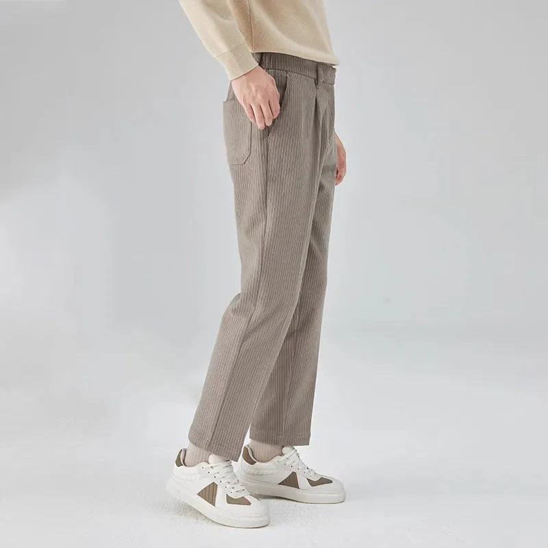 Men's beige straight-leg corduroy trousers with a mid waist and micro elasticity, laid flat.