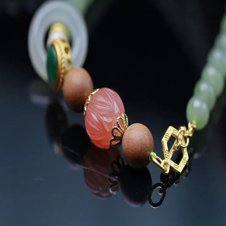 Hetian jade and red lotus bead necklace with matching bracelet on white sandalwood and beeswax.