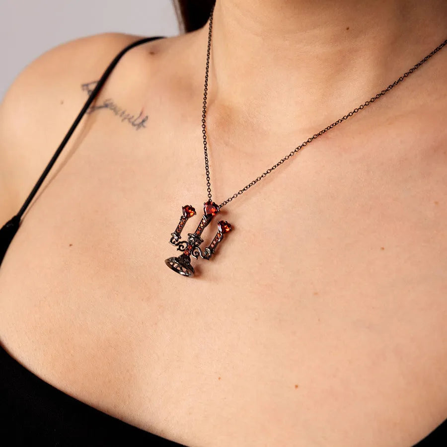A women's gothic-style necklace with a hollow candlestick pendant on a cross chain, in a retro candlestick colour.