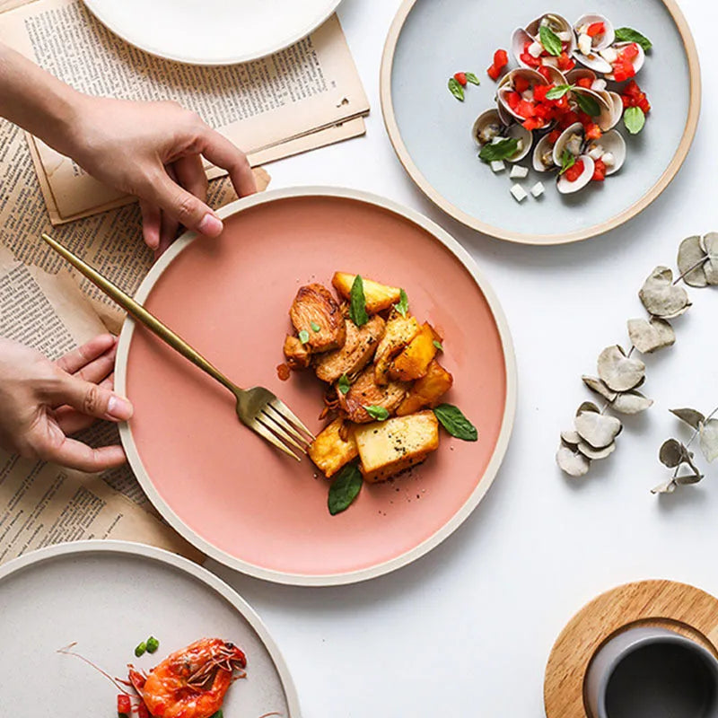 A 10-inch diameter pure blue matte ceramic dinner plate with a subtle textured finish on a wooden table.