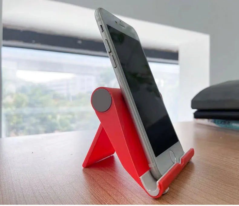Black PE folding mobile phone stand holding tablet at 45-degree angle on wooden desk