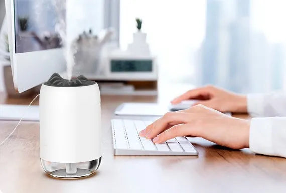 Mini cylindrical USB humidifier with night light in green, showing mist output and USB cable.