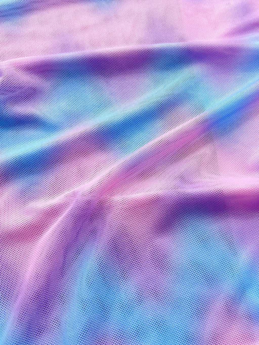 Women's tie-dye patterned bikini swimsuit with a removable skirt, showing bra top and briefs.