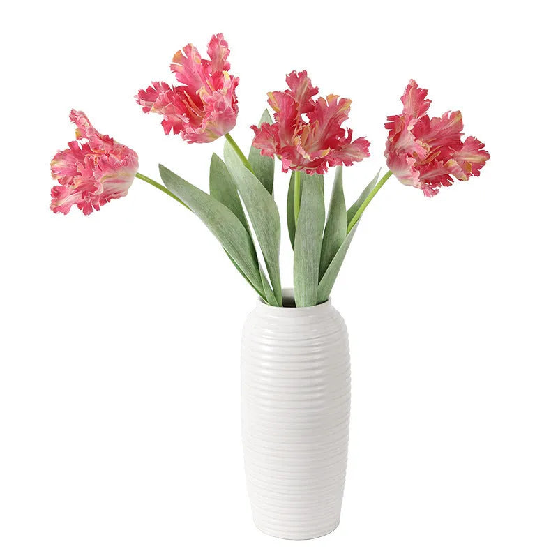 Artificial toothed tulip fake flower arrangement in bright red colour on wooden table