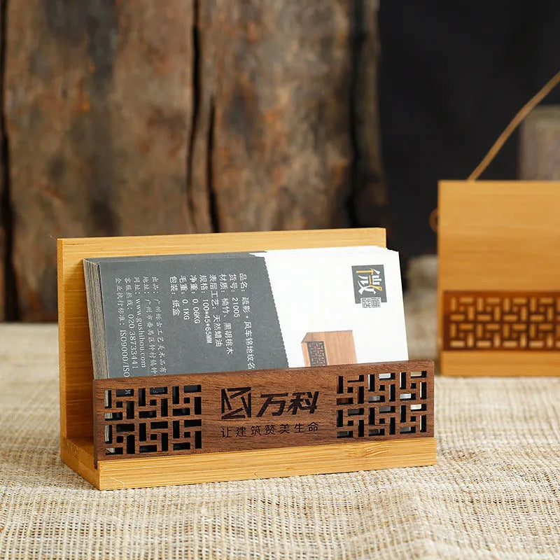 Geometric bamboo business card holder on a desk, showing natural wood grain and card slots.