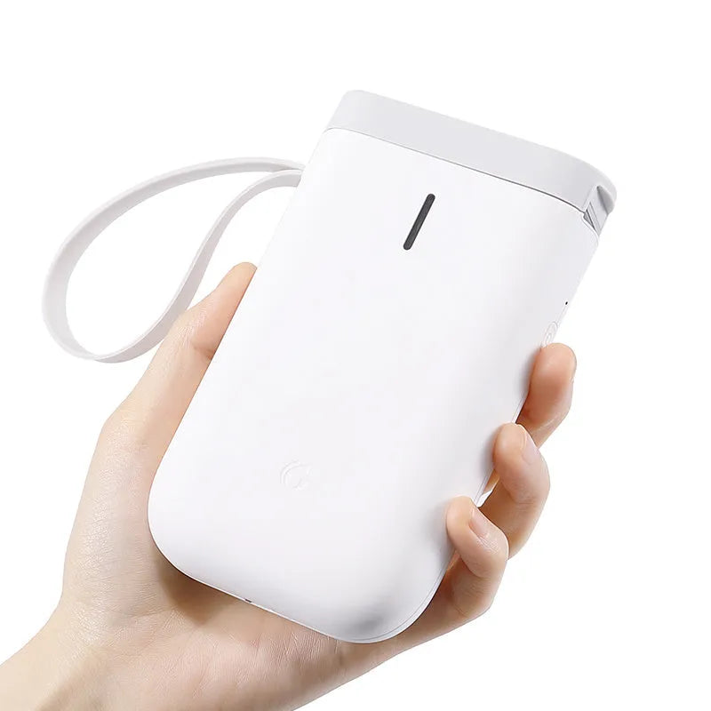 D11 compact Bluetooth thermal label printer in black on a desk next to a smartphone showing the control app.