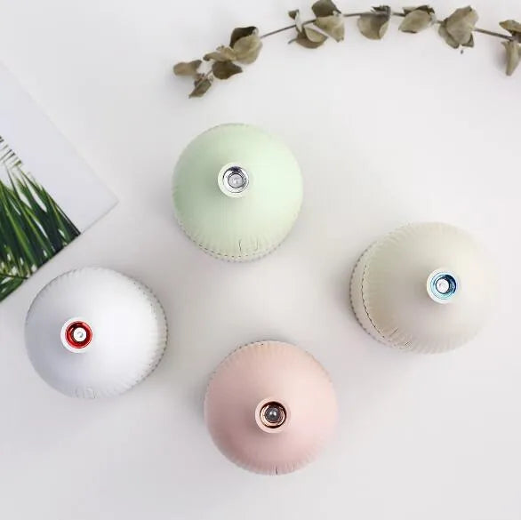 White ultrasonic aromatherapy diffuser with LED light, 300ml capacity, and USB cable on a wooden table