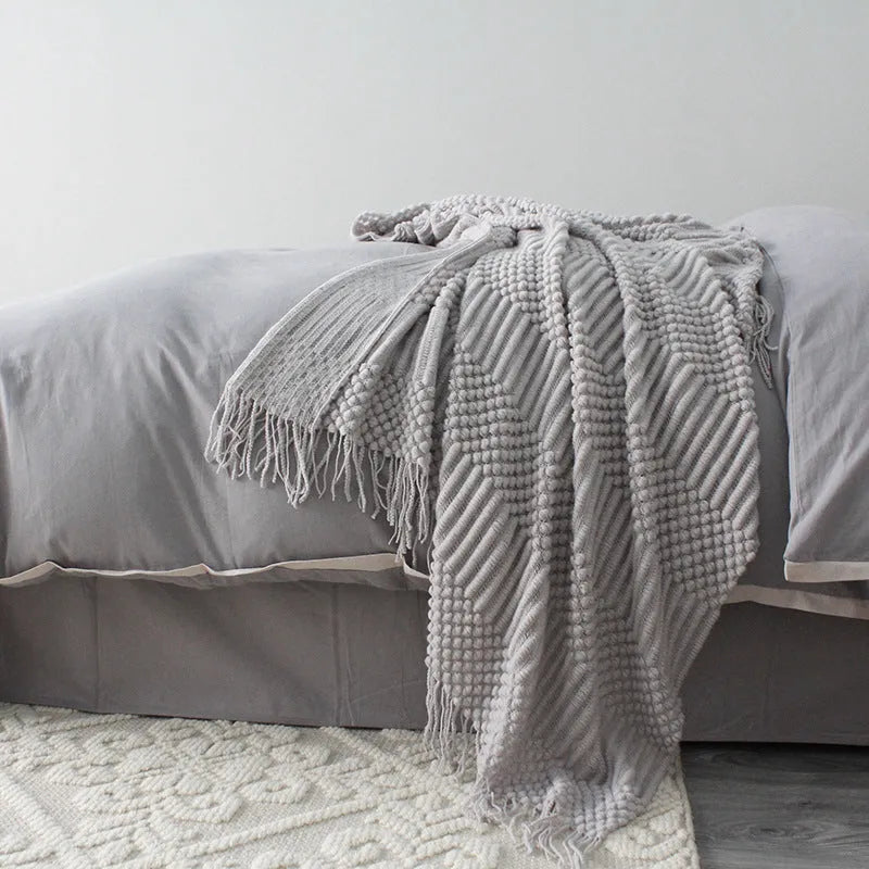 Small grey polyester nap blanket folded to show its texture and size.