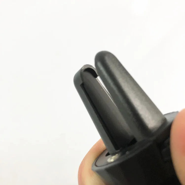 Black car phone holder attached to vehicle air vent with smartphone securely mounted