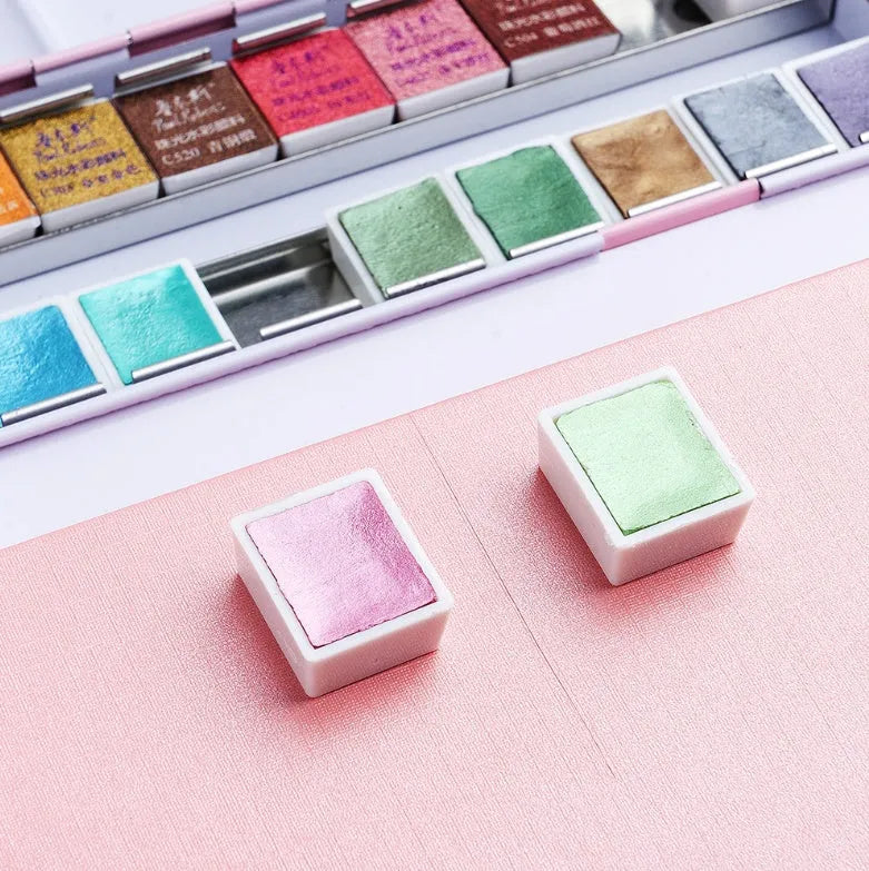 Solid watercolour paint set with pearl finish showing 12 or 24 colour pans in a case.