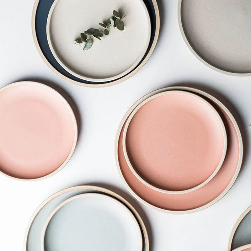 A 10-inch diameter pure blue matte ceramic dinner plate with a subtle textured finish on a wooden table.
