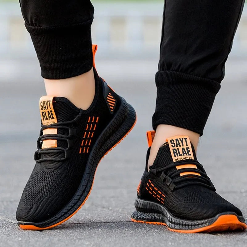 Men's sports shoes with Flying Weave upper, cross strap detailing, and wear-resistant soles in black, orange, or yellow colour options