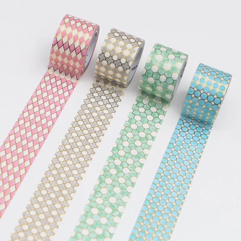 Rolls of Alice in Wonderland themed bronzing and paper tape in blue, gold, green, orange, and pink.