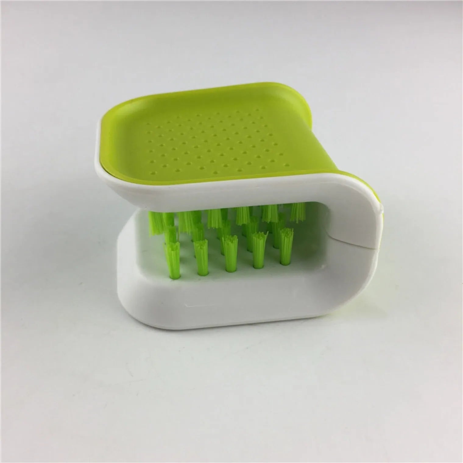 Blue U-shaped plastic brush for cleaning kitchen knives and cutlery on a kitchen counter.