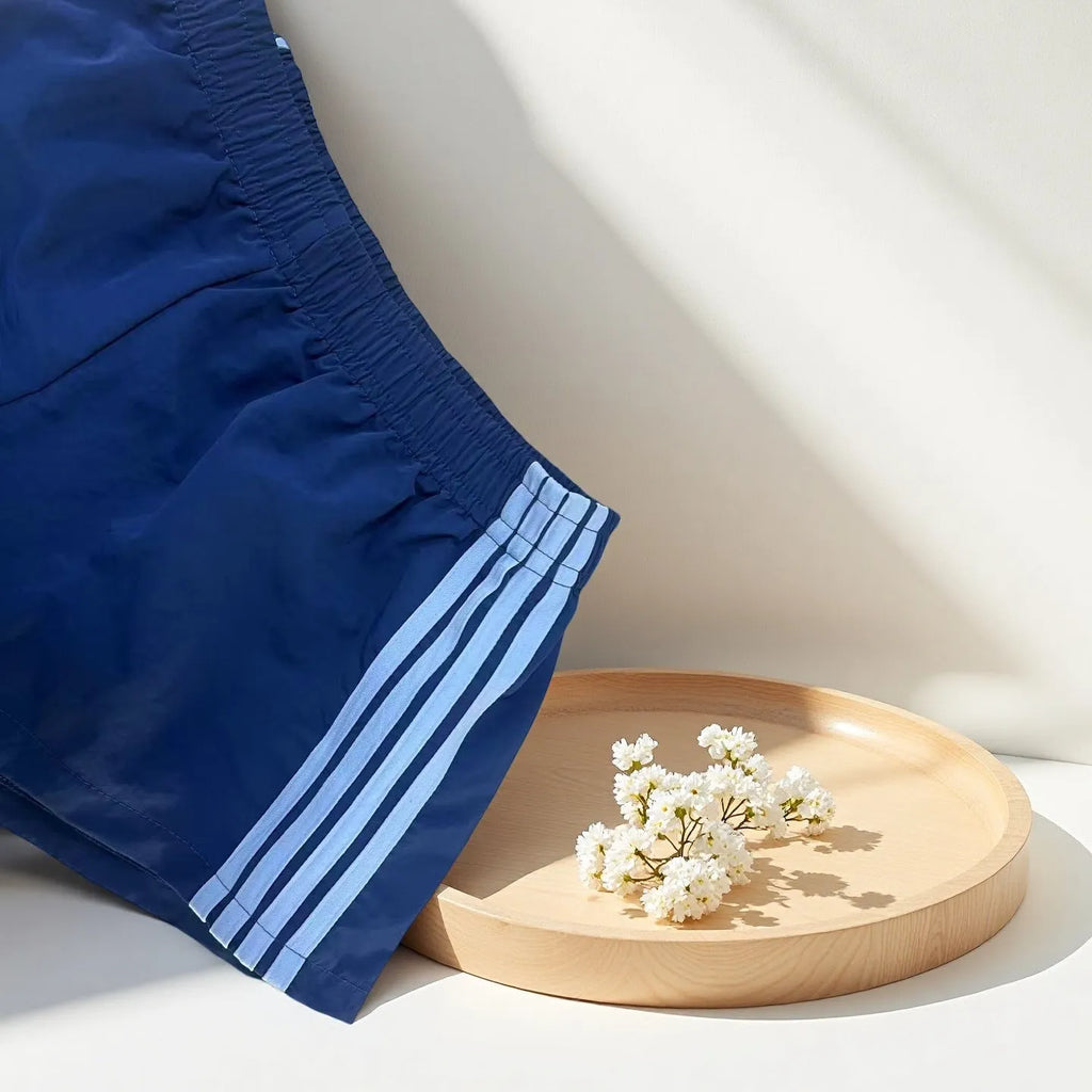 Navy blue men's high-waist nylon sports shorts on a white background