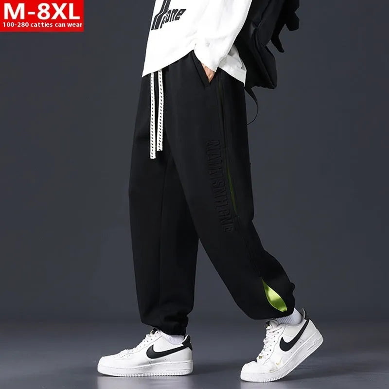 Men's ankle banded trousers in micro-elastic cotton with collage stitching, showing skinny leg and mid-waist fit.