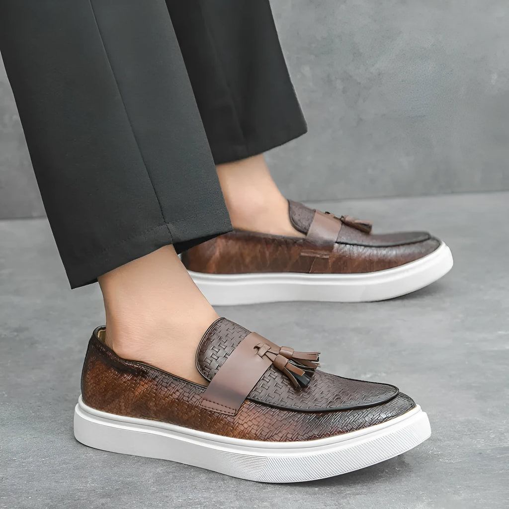 Men's black casual leather shoes with fringe detail on the upper and a low heel.