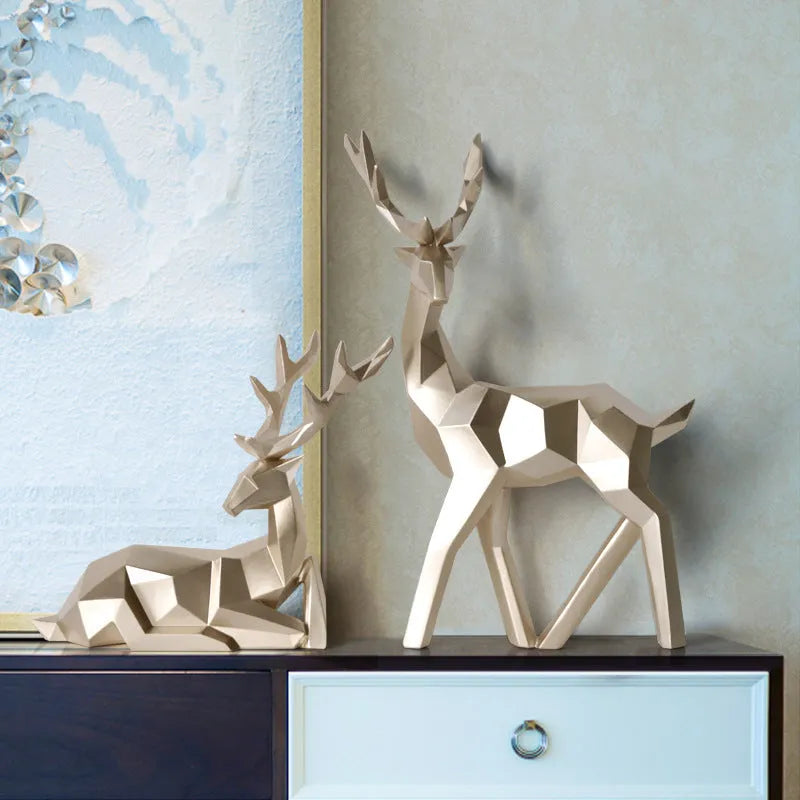 Set of three modern resin deer statues in graduated sizes on a shelf