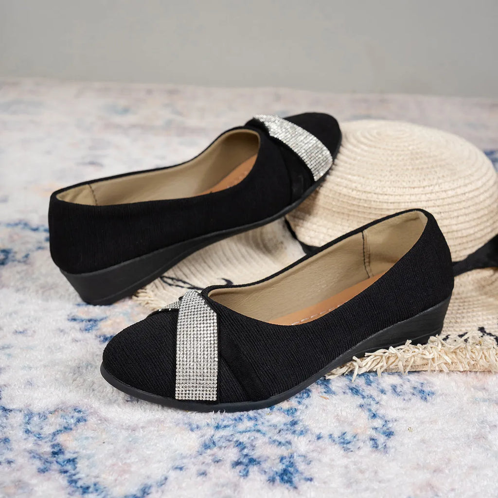 Women's black casual slip-on shoes with rhinestone details and a chunky heel on a white background.