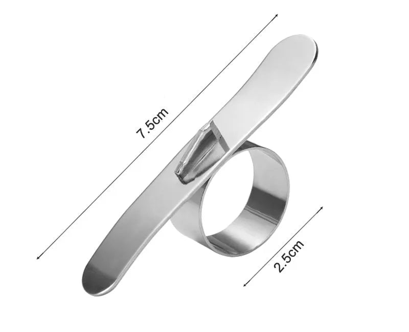A silver stainless steel finger-ring style citrus peeler for oranges and pomelo on a kitchen surface.