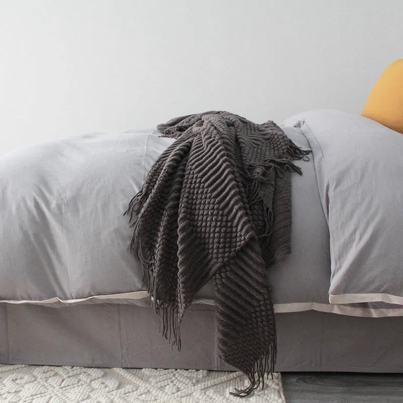 Small grey polyester nap blanket folded to show its texture and size.