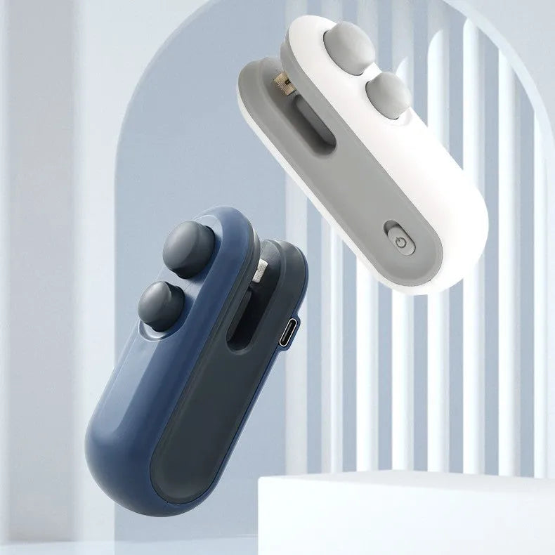 Blue and white handheld USB heat sealer with cutter blade on a magnetic metal surface.