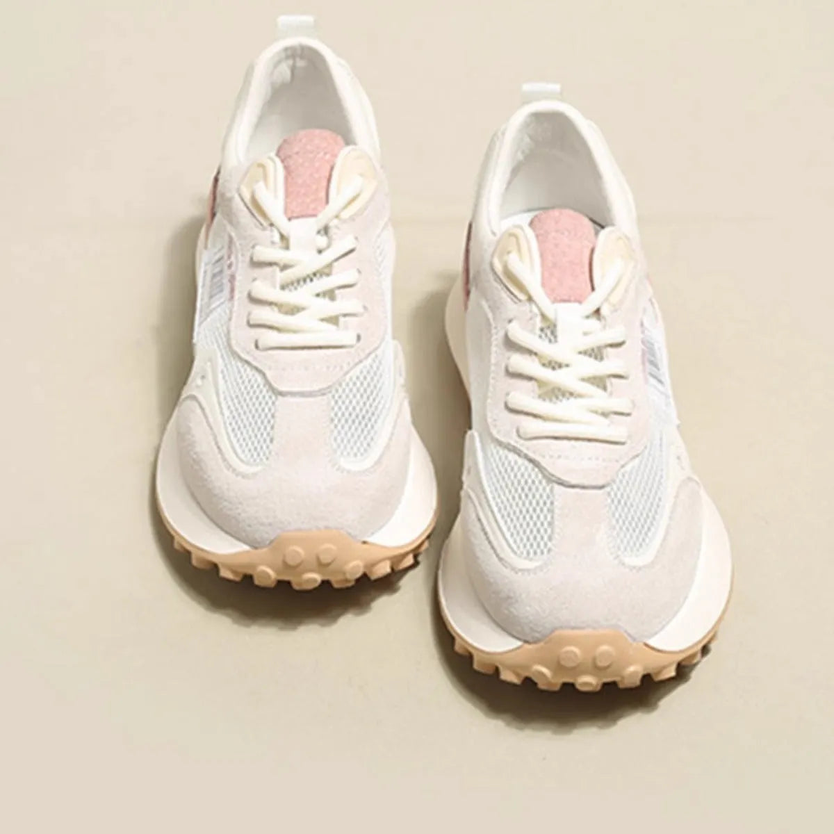 Women's grey and pink low-top retro sneaker with round toe and flat rubber sole.