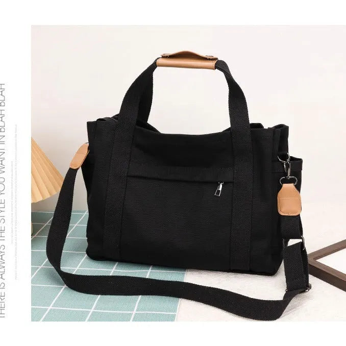 Horizontal square canvas tote bag with side zipper compartments and internal organisation pockets