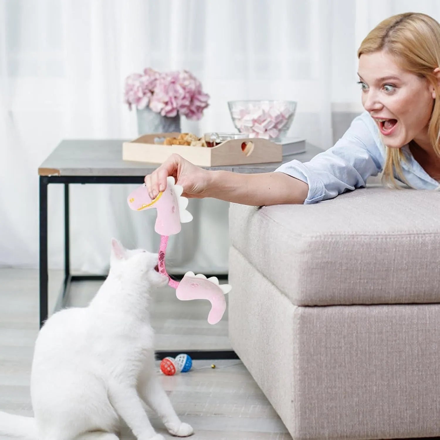 Four plush cat chew toys in pink, purple, and yellow colours showing mouse, fish, bunny, and catnip designs