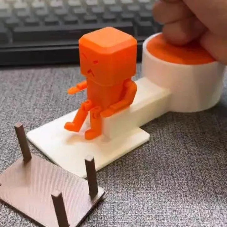 Orange plastic table-turning decompression toy measuring 16x6x7cm on wooden desk