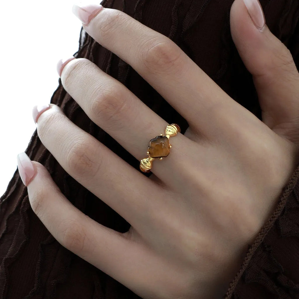 Adjustable silver ring with shell and tiger eye accents in gold electroplated finish showing opening mechanism