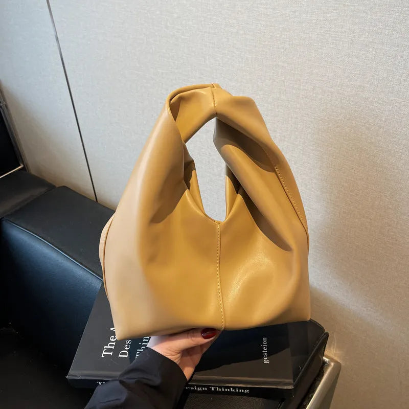 Dumpling-shaped women's handbag in various colours showing sandwich pocket design and fold-stitch details