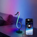 Black aluminium and iron APP-controlled LED atmosphere light with remote, showing 180-degree rotation on a desk.