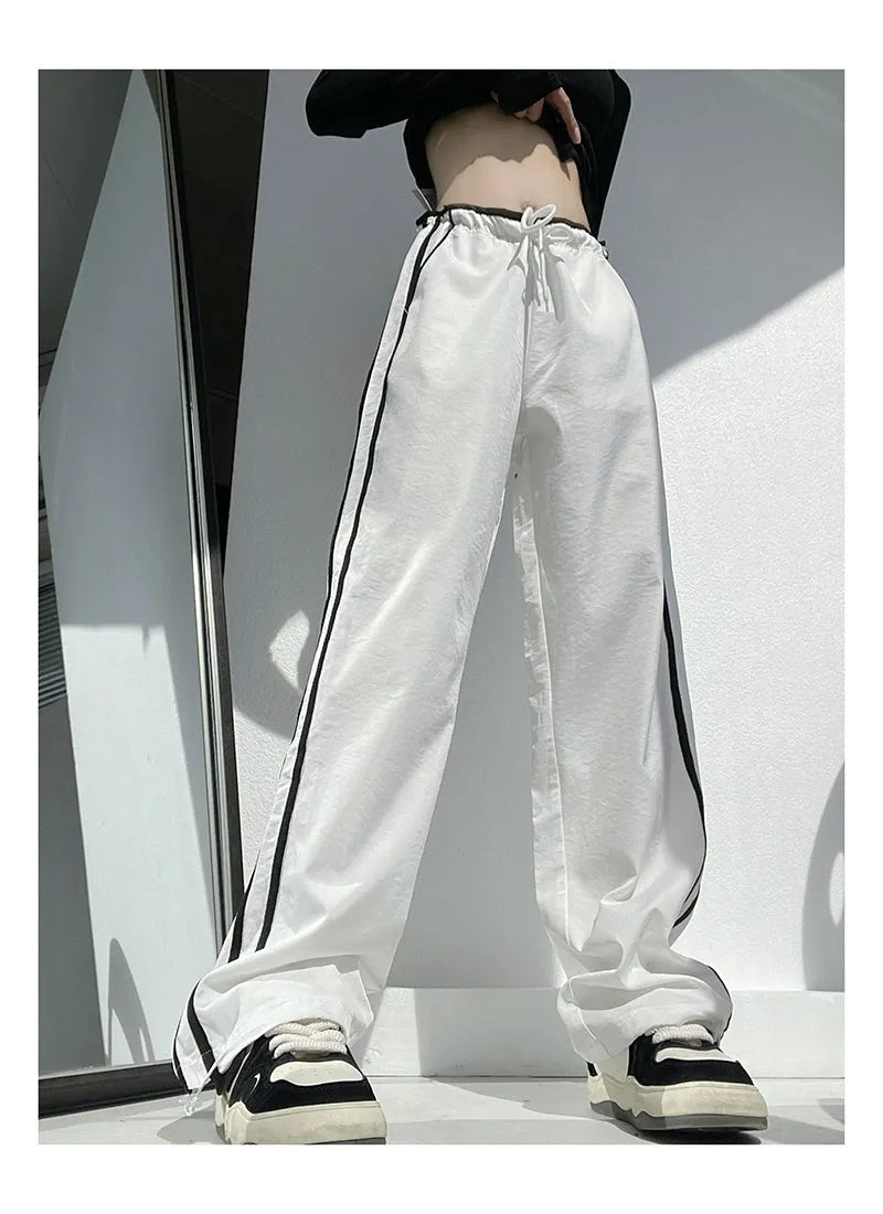Women's loose straight-leg trousers with ribbon contrast detail in white and navy blue.