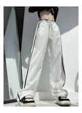 Women's loose straight-leg trousers with ribbon contrast detail in white and navy blue.