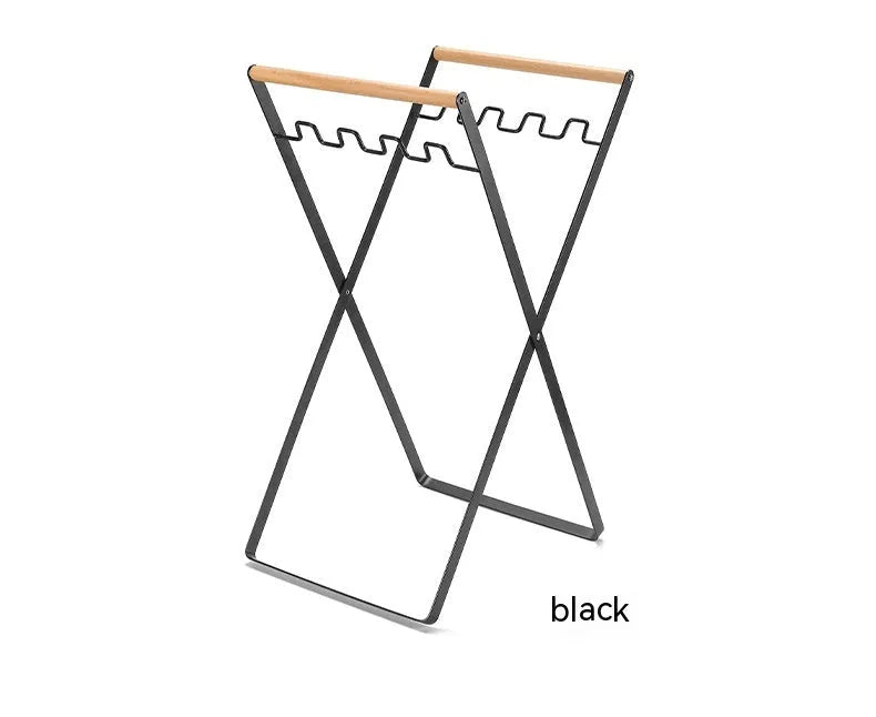 Black folding iron trash rack with wood handle holding bin bag outdoors