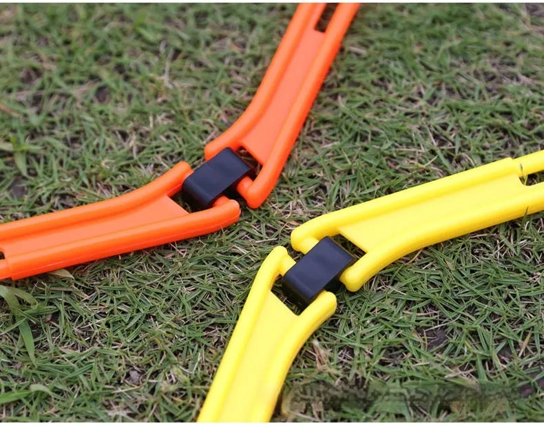 Set of six foldable yellow hexagon plastic agility training rings laid out on grass.