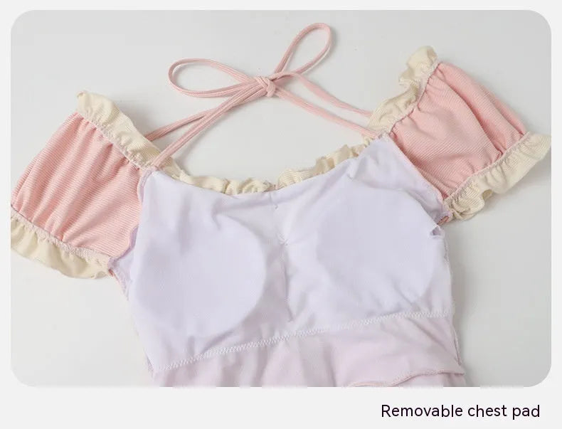 A pink women's conservative one-piece swimsuit on a white background.