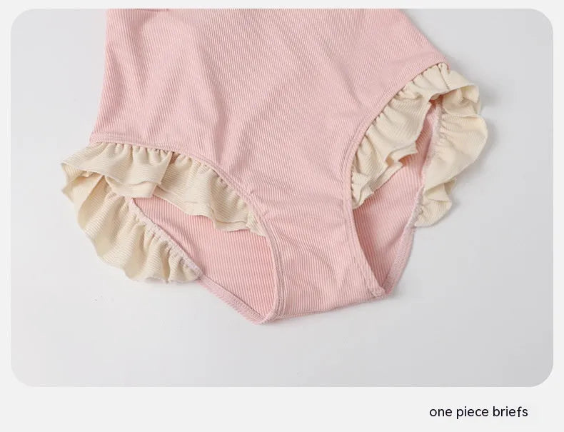 A pink women's conservative one-piece swimsuit on a white background.