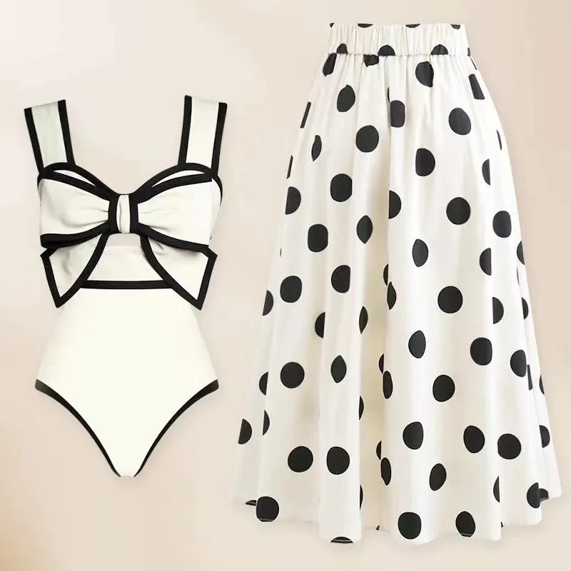 Women's black one-piece swimsuit with matching beach dress featuring bow and round skirt design