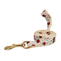 Red cherry printed cloth dog collar and leash set with matching vest, light gold buckle, and decorative bow strap.