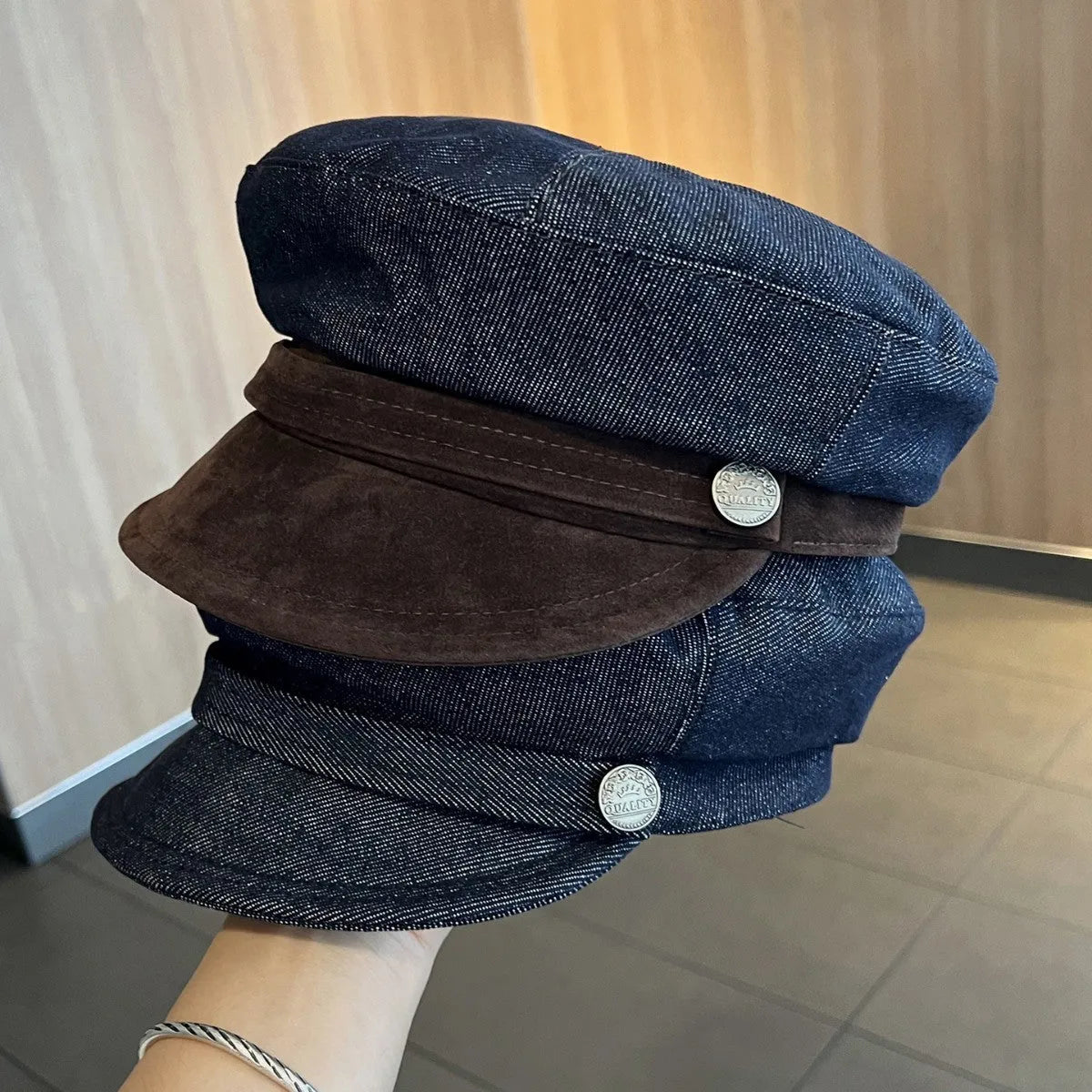 Dark blue denim British retro octagonal newsboy cap with an adjustable strap and coloured brim option on display.