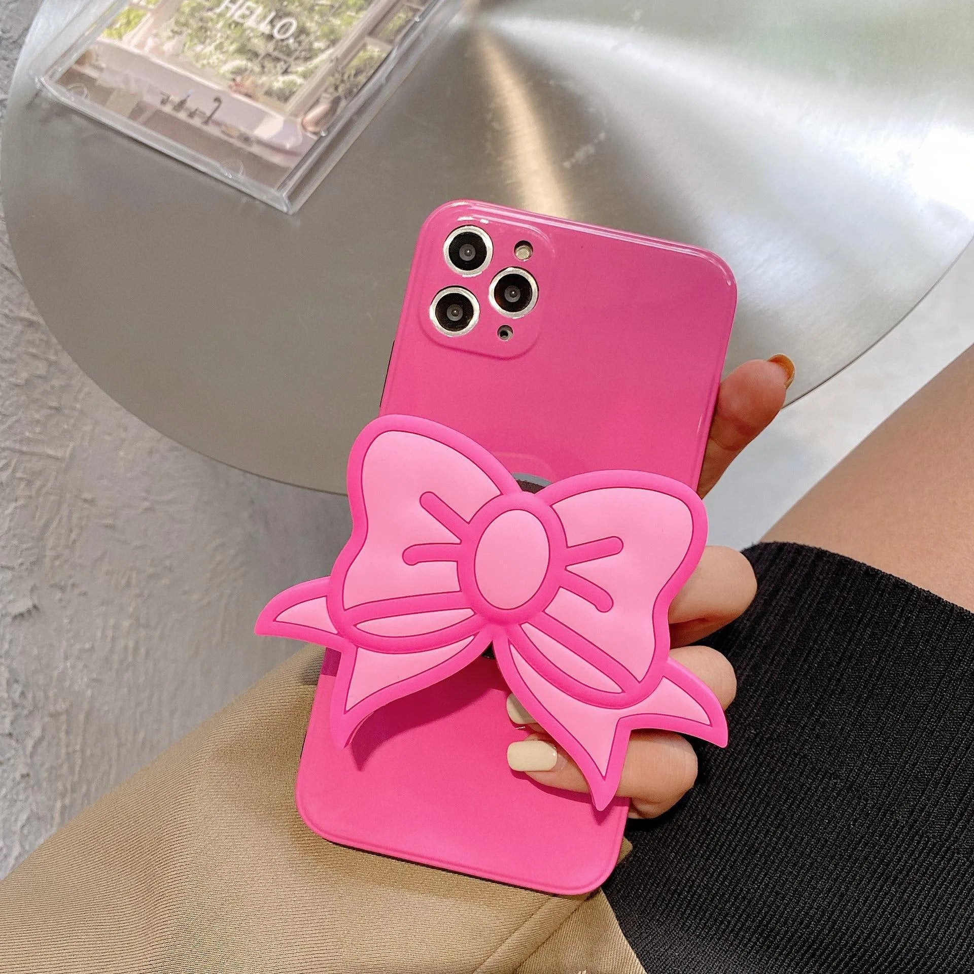 Rose Red iPhone case with pink bow design and a folded-out kickstand on the back.