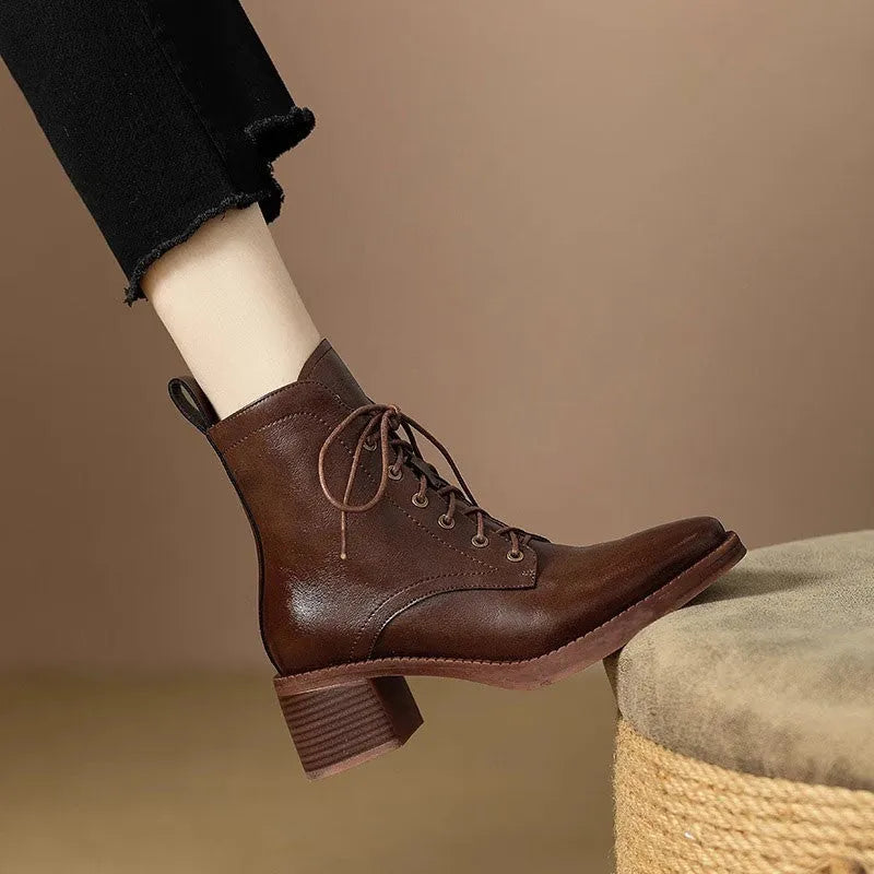 Women's black pointed-toe ankle boots with a short shaft and a low heel on a plain background.