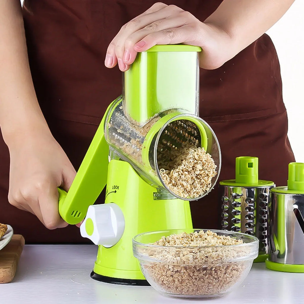 Blue green round mandoline slicer with three stainless steel drum blades and a suction base on a kitchen counter.