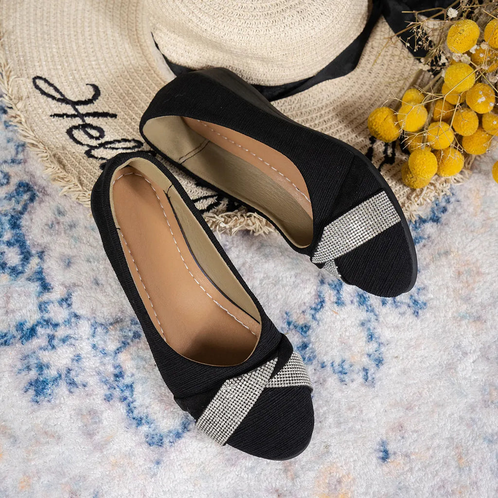 Women's black casual slip-on shoes with rhinestone details and a chunky heel on a white background.