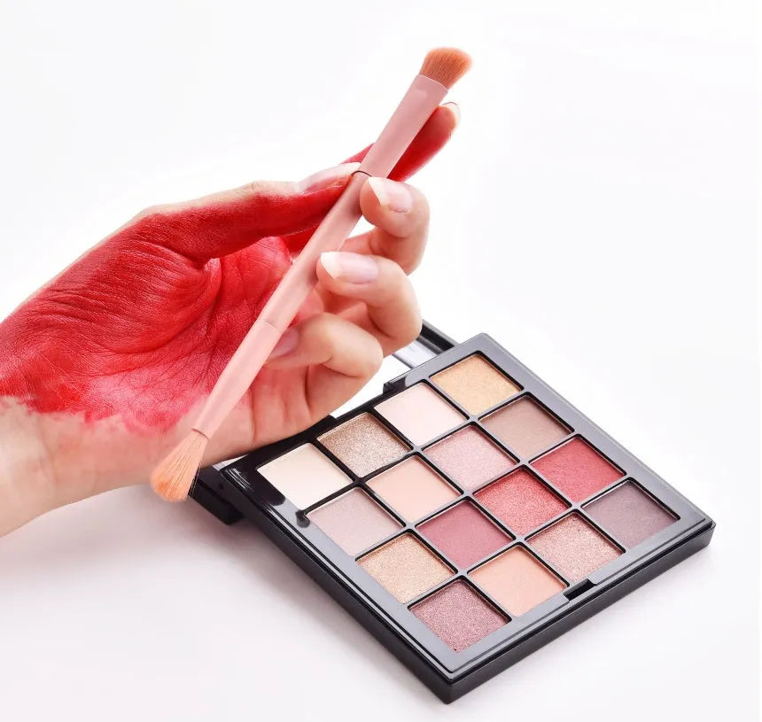10 cosmetic brushes with wooden handles and nylon bristles arranged with makeup products