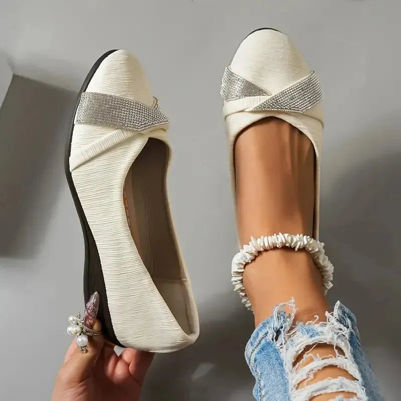 Women's black casual slip-on shoes with rhinestone details and a chunky heel on a white background.
