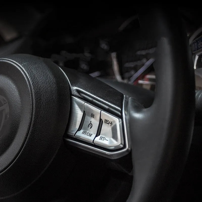 Set of eight aluminium alloy steering wheel button stickers in brushed red, silver, and blue finishes